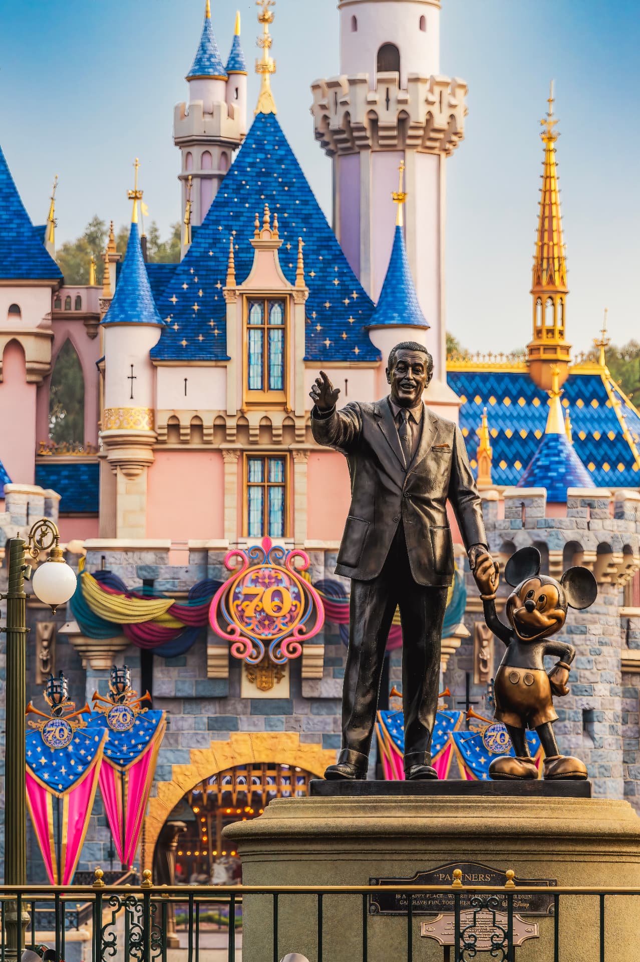 The Partners statue in front of Sleeping Beauty Castle dressed for the Disneyland 70th celebration