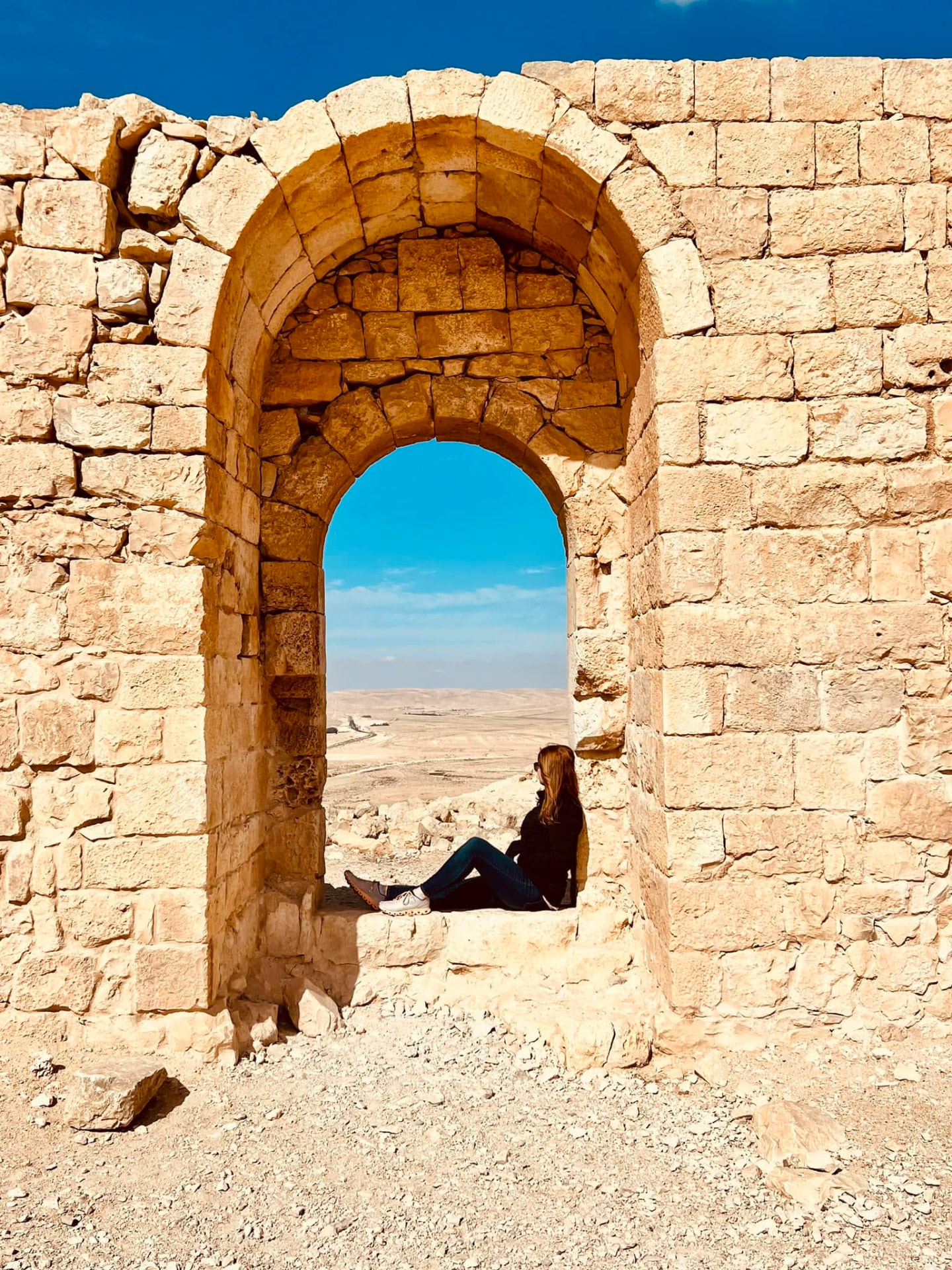 Sitting in a stone arch looking out over the desert in Israel