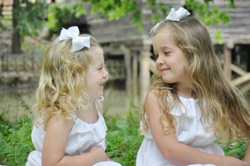 Two girls smiling at each other on a family trip