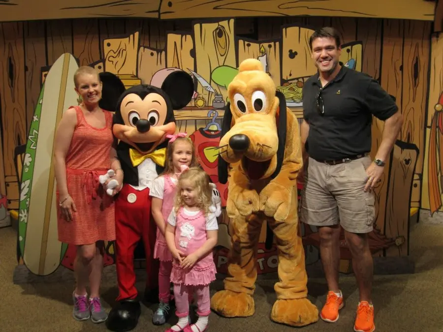 The family with Mickey and Pluto on the celebration trip
