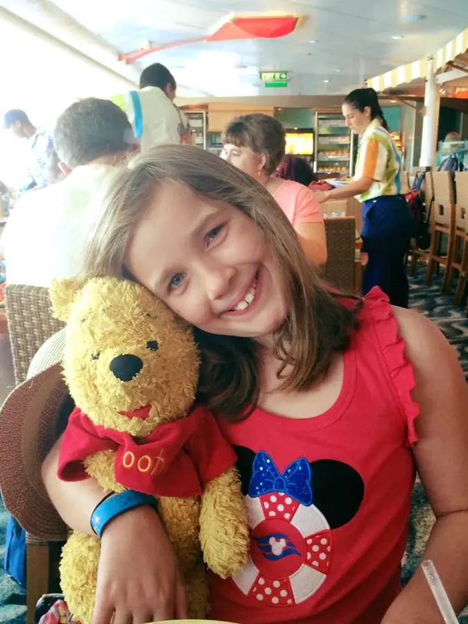 Annabeth hugging a Pooh Bear on a Disney cruise