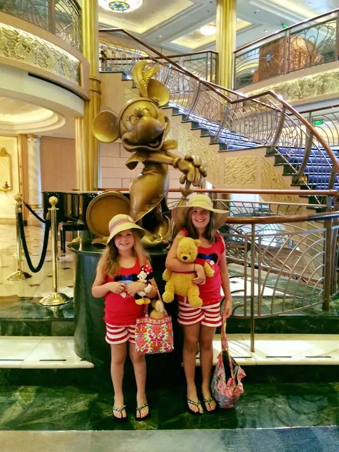 The girls in front of the Minnie statue in a Disney cruise ship atrium
